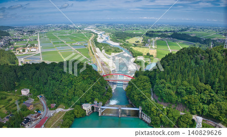 The red Aimoto Bridge spanning the Kurobe River and the surrounding area of the vast Kurobe River alluvial fan. The red Aimoto Bridge spanning the Kurobe River and the surrounding area of the vast Kurobe River alluvial fan. 140829626