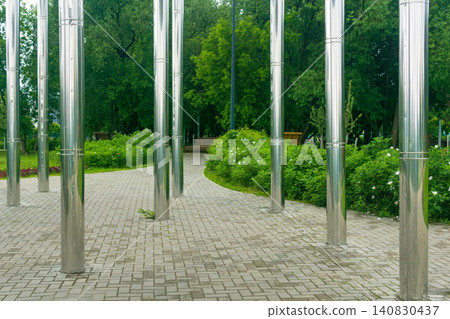 Landscape of city park with shiny metal poles. Landscape of city park with shiny metal poles. 140830437