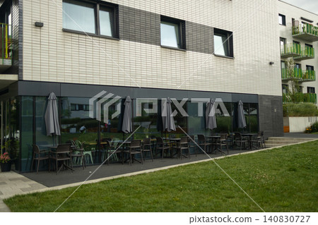 Modern apartment building facade with outdoor cafe on ground floor Modern apartment building facade with outdoor cafe on ground floor 140830727