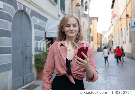 Young female tourist using smartphone application on beautiful European city street Young female tourist using smartphone application on beautiful European city street 140830794
