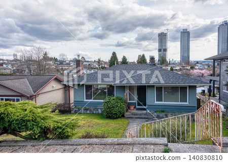 Suburban Residential Bungalow House with Modern City Skyline Background Suburban Residential Bungalow House with Modern City Skyline Background 140830810