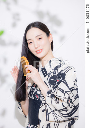 A woman in a yukata doing hair care. A woman in a yukata doing hair care. 140831476