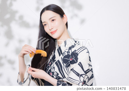 A woman in a yukata doing hair care. A woman in a yukata doing hair care. 140831478