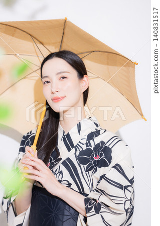 A young woman in a yukata carrying a parasol. A young woman in a yukata carrying a parasol. 140831517