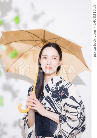 身穿浴衣、手持陽傘的年輕女子。 身穿浴衣、手持陽傘的年輕女子。 140831519