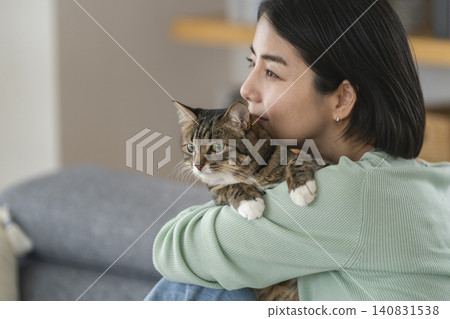 一位三十多歲的女子抱著一隻貓 一位三十多歲的女子抱著一隻貓 140831538