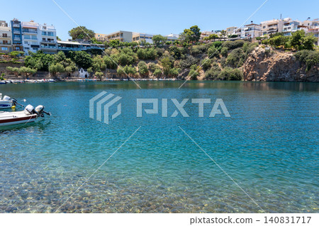 Lake Voulismeni with transparent turquoise water and coastal town architecture in Agios Nikolaos, Crete, Greece Lake Voulismeni with transparent turquoise water and coastal town architecture in Agios Nikolaos, Crete, Greece 140831717