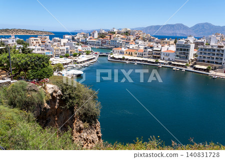 High angle panoramic view of Lake Voulismeni with rocky cliff and seaside town architecture in Agios Nikolaos, Crete, Greece High angle panoramic view of Lake Voulismeni with rocky cliff and seaside town architecture in Agios Nikolaos, Crete, Greece 140831728