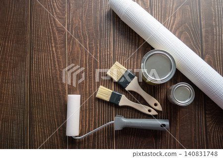 Brushes, wallpaper roll and metal can with paint for repair in a house or apartment on the wood background. Tools for renovation. Brushes, wallpaper roll and metal can with paint for repair in a house or apartment on the wood background. Tools for renovation. 140831748