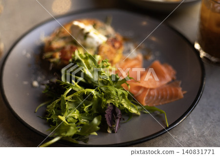 Salmon breakfast platter with green salad served on a dark ceramic plate 140831771