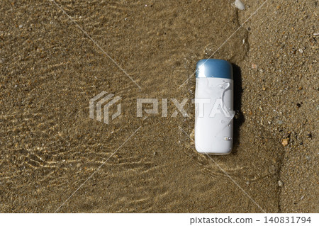 Sunscreen bottle on wet sand with clear water splashes, ideal for summer protection Sunscreen bottle on wet sand with clear water splashes, ideal for summer protection 140831794