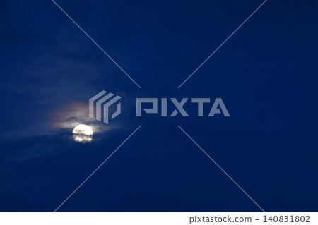 full moon floating and covering by dark cloud on blue sky in twilight background full moon floating and covering by dark cloud on blue sky in twilight background 140831802