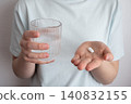 Girl in blue t-shirt take the pill and glass with water in the hand. Healthcare from pharmacy. Kid sit at home because of illness. 140832155
