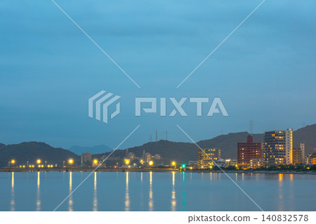 夜晚,城市燈光美麗地倒映在水面上。 夜晚,城市燈光美麗地倒映在水面上。 140832578