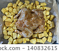 Roasted chicken with seasoned potatoes on baking sheet in a savory and hearty home-cooked style 140832615