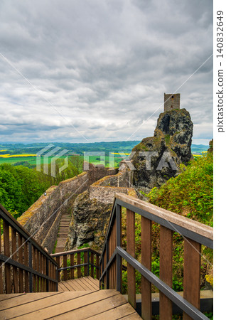 Iconic towers of Trosky Castle Ruins rising on ancient volcanic rock formations beneath dramatic stormy skies in the beautiful Bohemian Paradise, Czech Republic. Iconic towers of Trosky Castle Ruins rising on ancient volcanic rock formations beneath dramatic stormy skies in the beautiful Bohemian Paradise, Czech Republic. 140832649