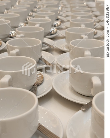 Receding Rows of White Teacups and Saucers on Banquet Table Receding Rows of White Teacups and Saucers on Banquet Table 140832967