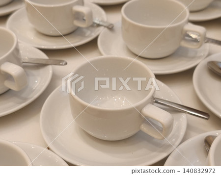 Single White Teacup in Focus Among Rows of Matching Cups 140832972