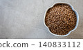 Gray bowl with uncooked roasted buckwheat on the light stone table for healthy food. Cooking concept. Top view. 140833112