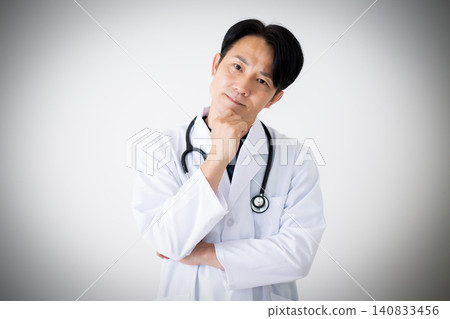 A middle-aged male doctor in a white coat is troubled. A middle-aged male doctor in a white coat is troubled. 140833456