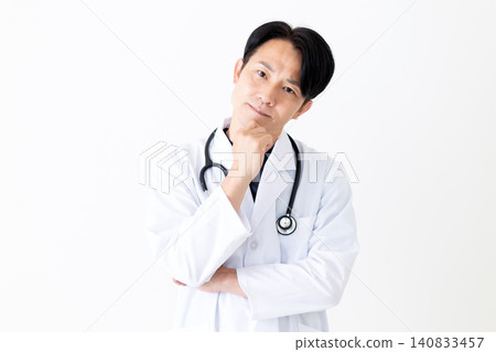 A middle-aged male doctor in a white coat is troubled. A middle-aged male doctor in a white coat is troubled. 140833457