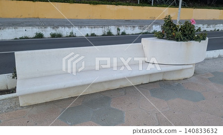 Unique white long bench integrated with the flowerbed on the street Unique white long bench integrated with the flowerbed on the street 140833632