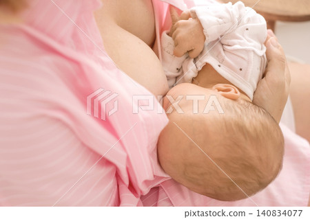 Close-up of a baby with its mother drinking breast milk. Proper nutrition and feeding of newborns. 140834077