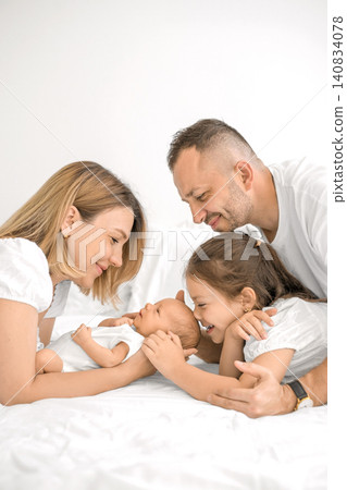 A newborn boy surrounded by his parents and older sister. Love and nurturing in harmony. 140834078