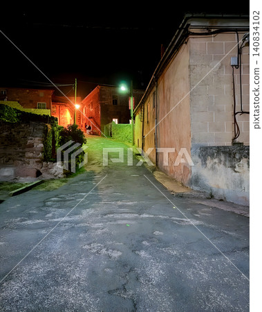 Empty village street at night with green streetlight glow in Barcones, Spain Empty village street at night with green streetlight glow in Barcones, Spain 140834102
