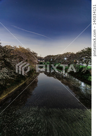 The reflection of cherry trees beautifully adorning the river surface at night, creating a fantastical night view of floating flowers. The reflection of cherry trees beautifully adorning the river surface at night, creating a fantastical night view of floating flowers. 140834151