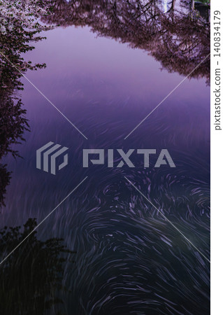 夕陽西下,河水被染成紫色,在河面上勾勒出美麗的櫻花漩渦圖案和流暢的線條。 夕陽西下,河水被染成紫色,在河面上勾勒出美麗的櫻花漩渦圖案和流暢的線條。 140834179