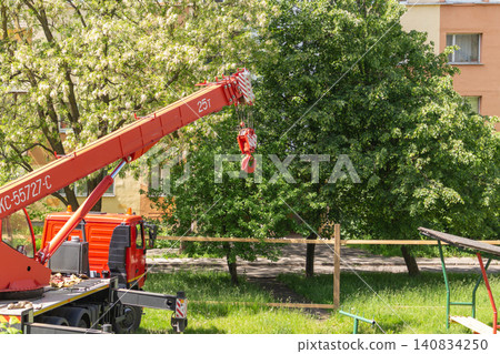 Heavy telescopic crane truck with extended outriggers on urban lawn Heavy telescopic crane truck with extended outriggers on urban lawn 140834250