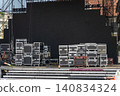 Outdoor concert stage setup with stacked road cases 140834324