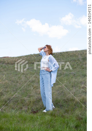 Woman Walking in a Green Field on Rolling Hills, Embracing Freedom and Nature Woman Walking in a Green Field on Rolling Hills, Embracing Freedom and Nature 140834551