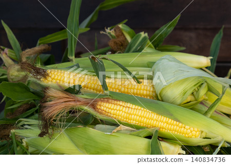 Fresh sweet corn cobs on rustic wood. Whole corn with bright yellow kernels. Organic farm produce for healthy meals Fresh sweet corn cobs on rustic wood. Whole corn with bright yellow kernels. Organic farm produce for healthy meals 140834736