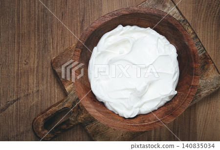 sour cream in a wooden bowl, on a wooden table, top view, close-up, no people, sour cream in a wooden bowl, on a wooden table, top view, close-up, no people, 140835034
