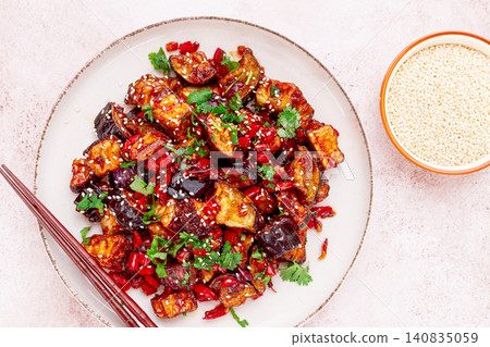 fried eggplant, Chinese style, in sweet and sour sauce, with pepper and sesame seeds. on a white plate, fried eggplant, Chinese style, in sweet and sour sauce, with pepper and sesame seeds. on a white plate, 140835059