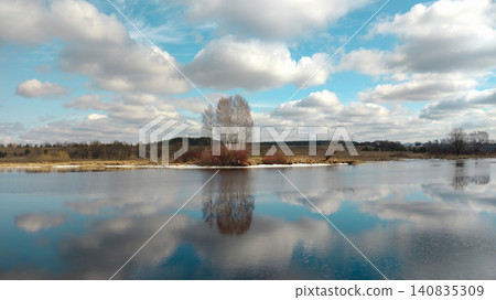 Scenic landscape with a calm river and reflections of trees and clouds. Scenic landscape with a calm river and reflections of trees and clouds. 140835309