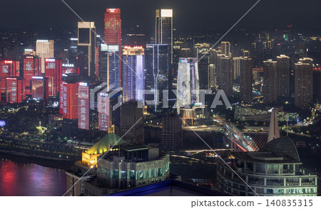 Skyscrapers rise majestically, illuminated by neon blues, vivid crimsons, and stark whites. Vertical light bands mimic glowing waterfalls, while geometric frameworks trace silhouettes against the Skyscrapers rise majestically, illuminated by neon blues, vivid crimsons, and stark whites. Vertical light bands mimic glowing waterfalls, while geometric frameworks trace silhouettes against the 140835315
