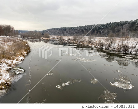 Winter river landscape with snowy banks and pine forest Winter river landscape with snowy banks and pine forest 140835331