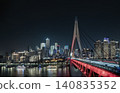 Dominating the foreground, the magnificent Qiansimen Bridge carves through the darkness over the water. Its soaring, bone-white pylon rises smoothly against the night sky, while its lower truss glows 140835352