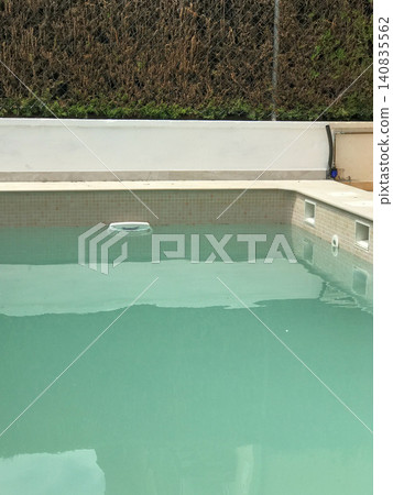 Swimming pool with turquoise water and skimmer Swimming pool with turquoise water and skimmer 140835562