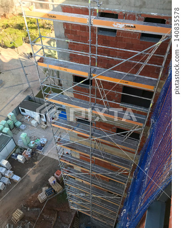 Construction site with scaffolding on urban building facade 140835578