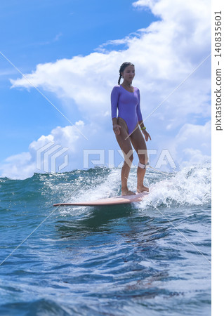 Teenage Girl Skillfully Balancing On Wave During Serene Coastal Surfing Session Teenage Girl Skillfully Balancing On Wave During Serene Coastal Surfing Session 140835601