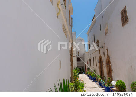A narrow street with white walls leads to a beautiful blue door in the Kasbah of Rabat, Morocco. A narrow street with white walls leads to a beautiful blue door in the Kasbah of Rabat, Morocco. 140836084