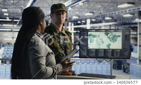 Military technology team reviews a digital world map in a server room to coordinate mission zones with AI support. Military technology team reviews a digital world map in a server room to coordinate mission zones with AI support. 140836577