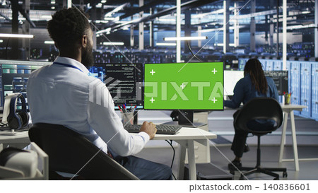 Data infrastructure center IT specialist operates replaceable display computer to apply deep learning visual programming tech assessing datasets. 140836601