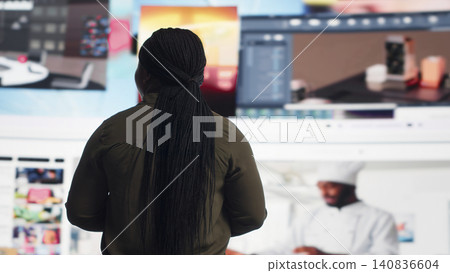 African American woman watches a video wall, enjoying digital lifestyle content, social media technology and global online connection. African American woman watches a video wall, enjoying digital lifestyle content, social media technology and global online connection. 140836604