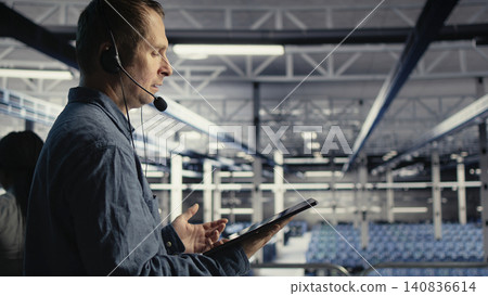 IT specialist uses digital device in a server farm to plan disaster recovery and strengthen data protection. IT specialist uses digital device in a server farm to plan disaster recovery and strengthen data protection. 140836614