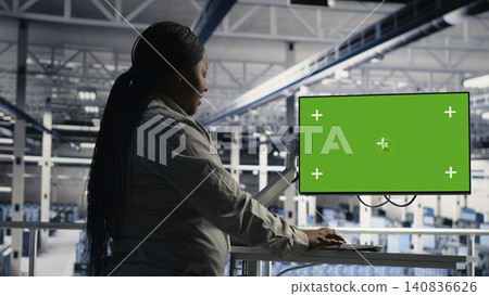 African American software developer uses a chroma key workstation in a server hub to scan equipment issues and perform backups. African American software developer uses a chroma key workstation in a server hub to scan equipment issues and perform backups. 140836626